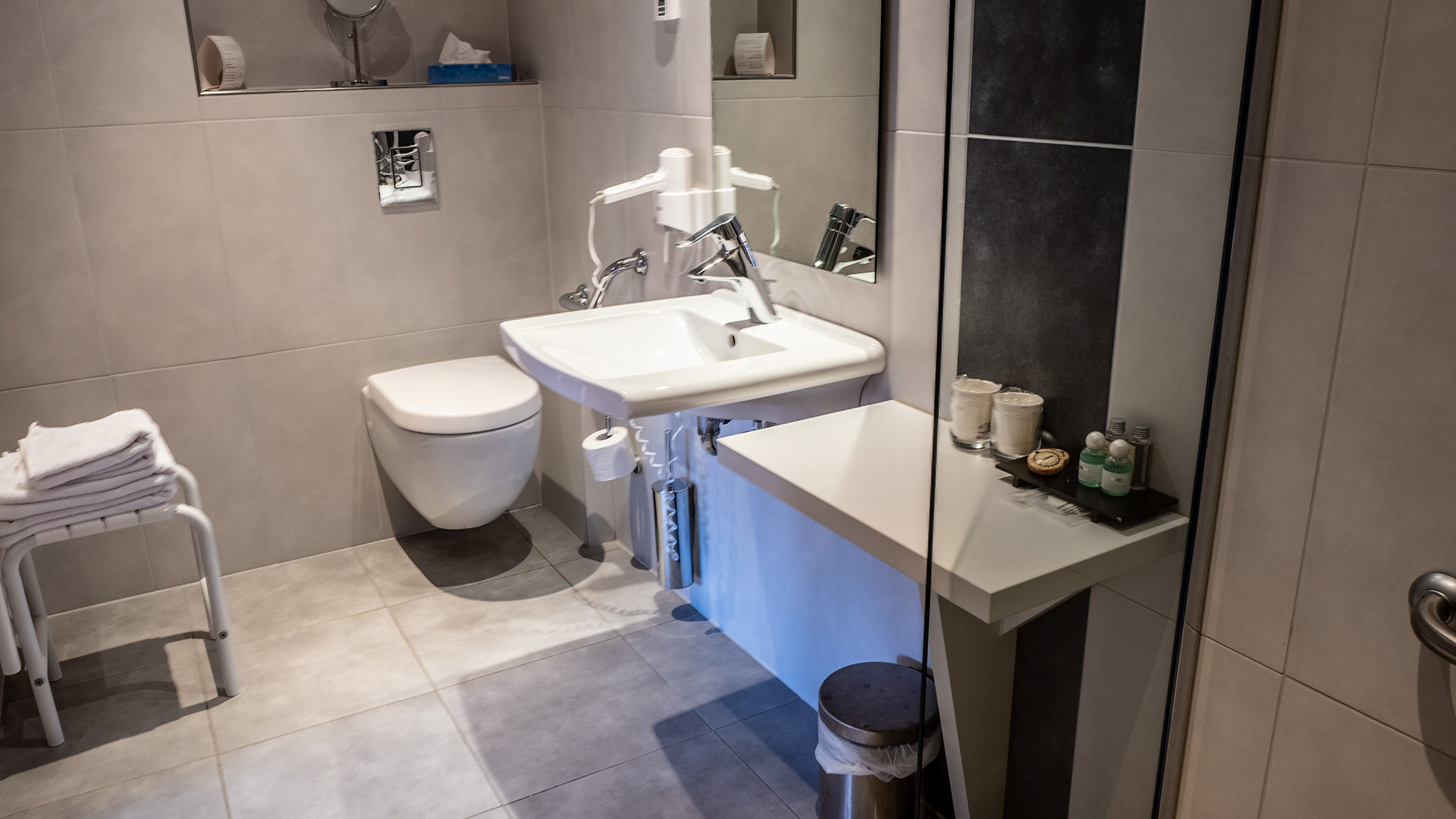Vue complémentaire de la salle de bains avec lavabo, WC suspendu et accessoires