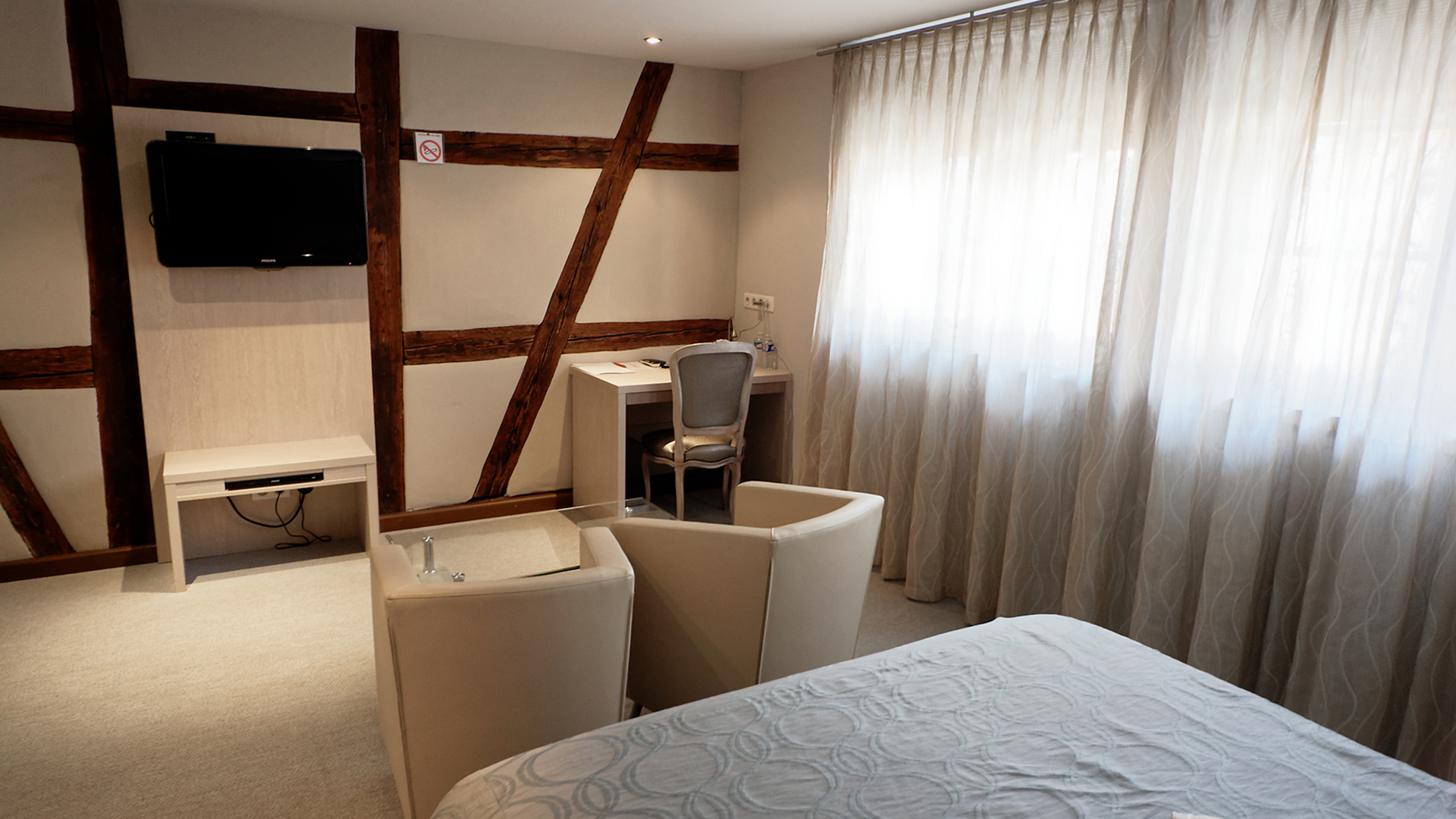 Chambre 36 avec grandes fenêtres, lit double et coin salon lumineux