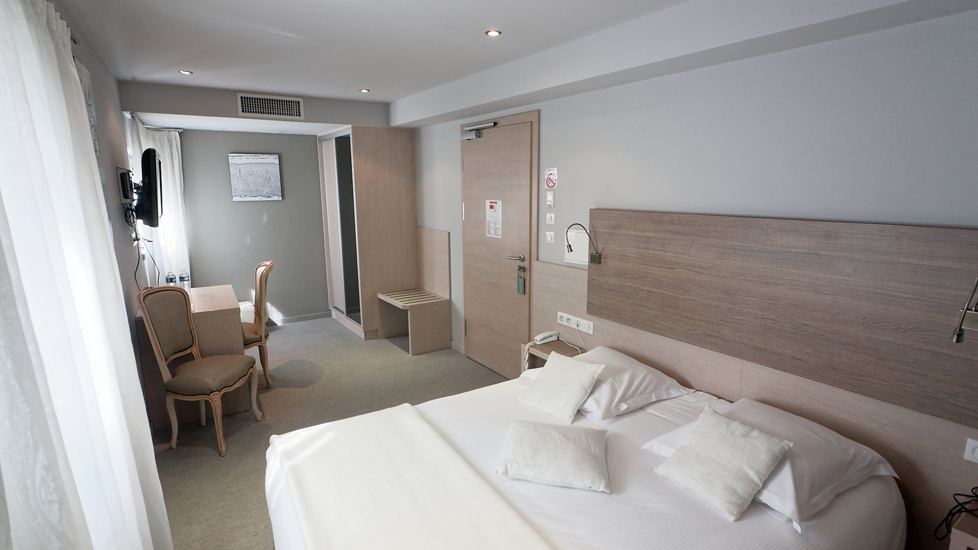 Vue complète de la chambre 37, coin bureau et télévision murale inclus