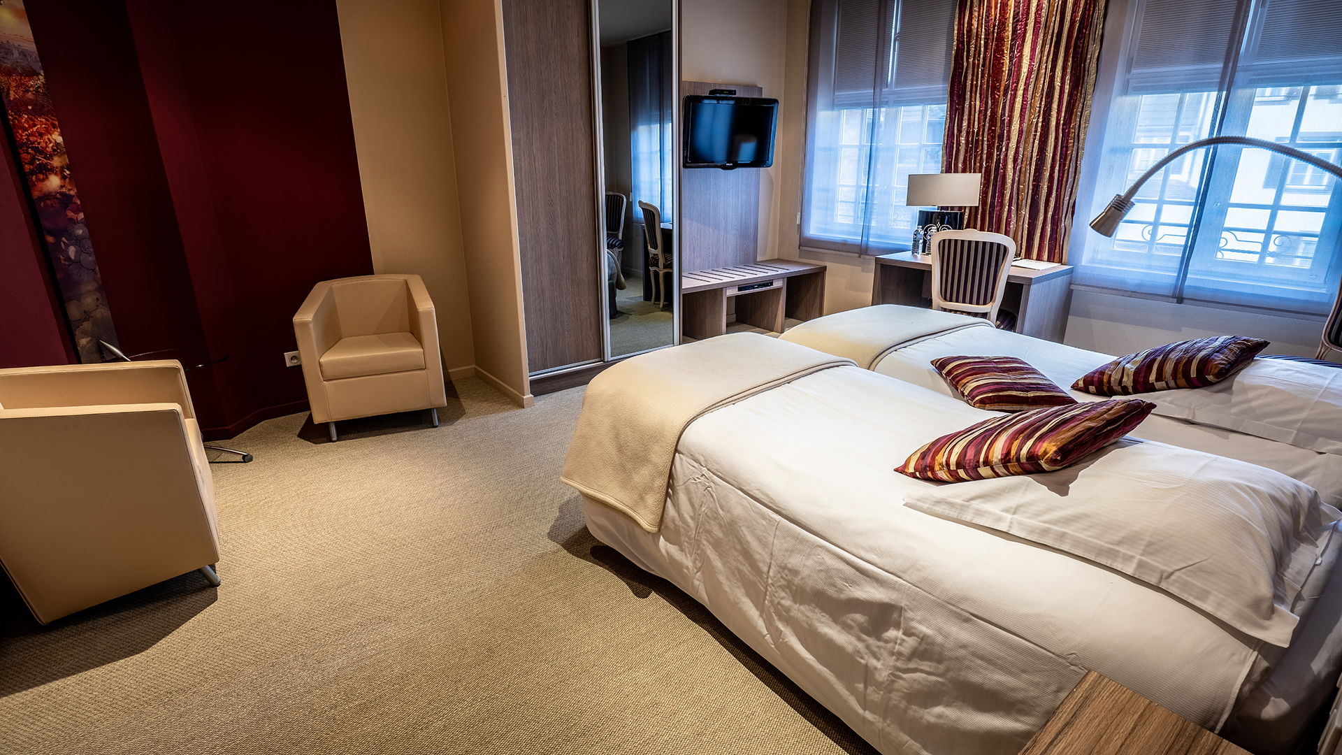 Chambre avec lits jumeaux et coin détente.