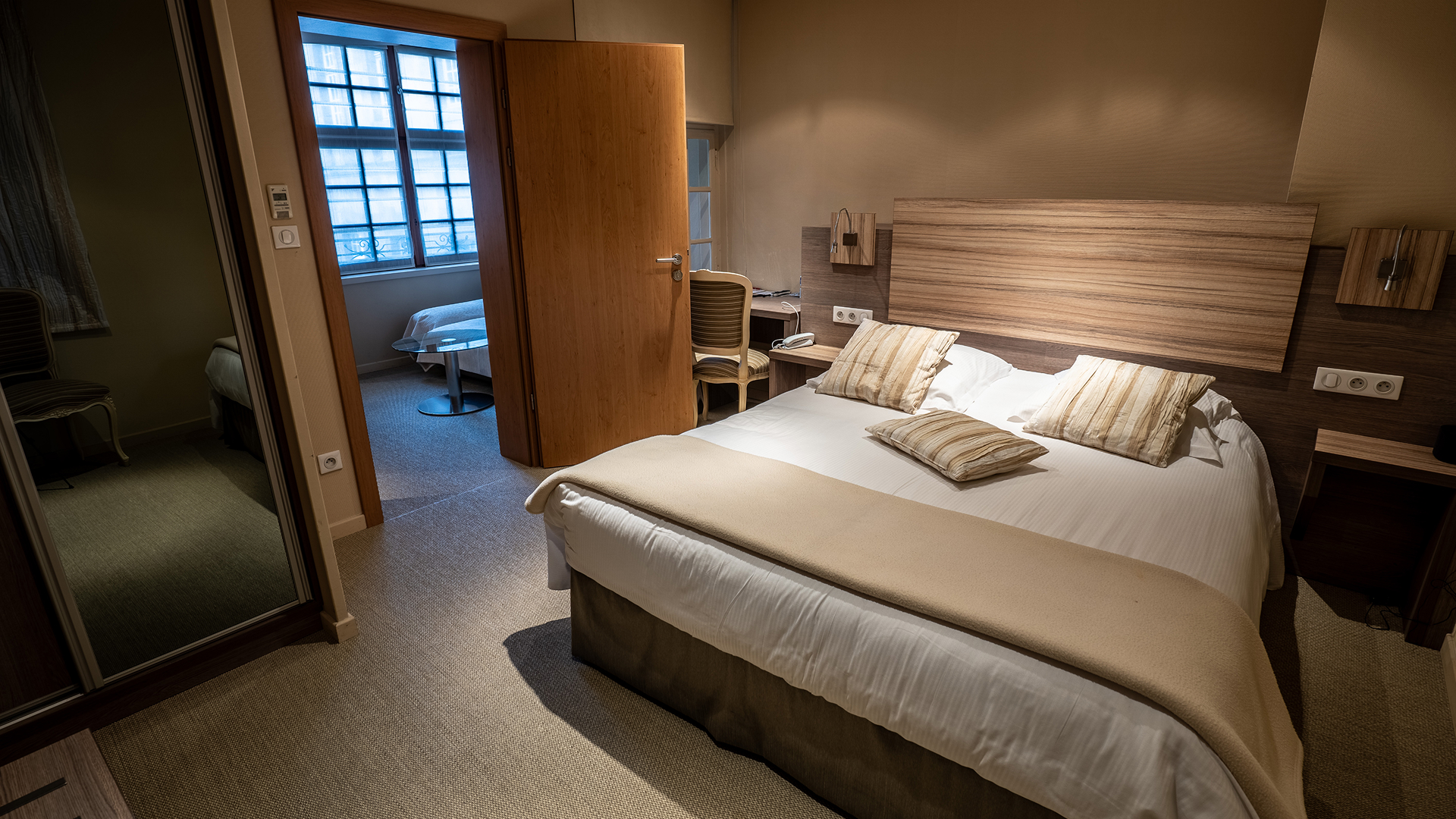 Chambre principale avec lit double et accès au salon privé.