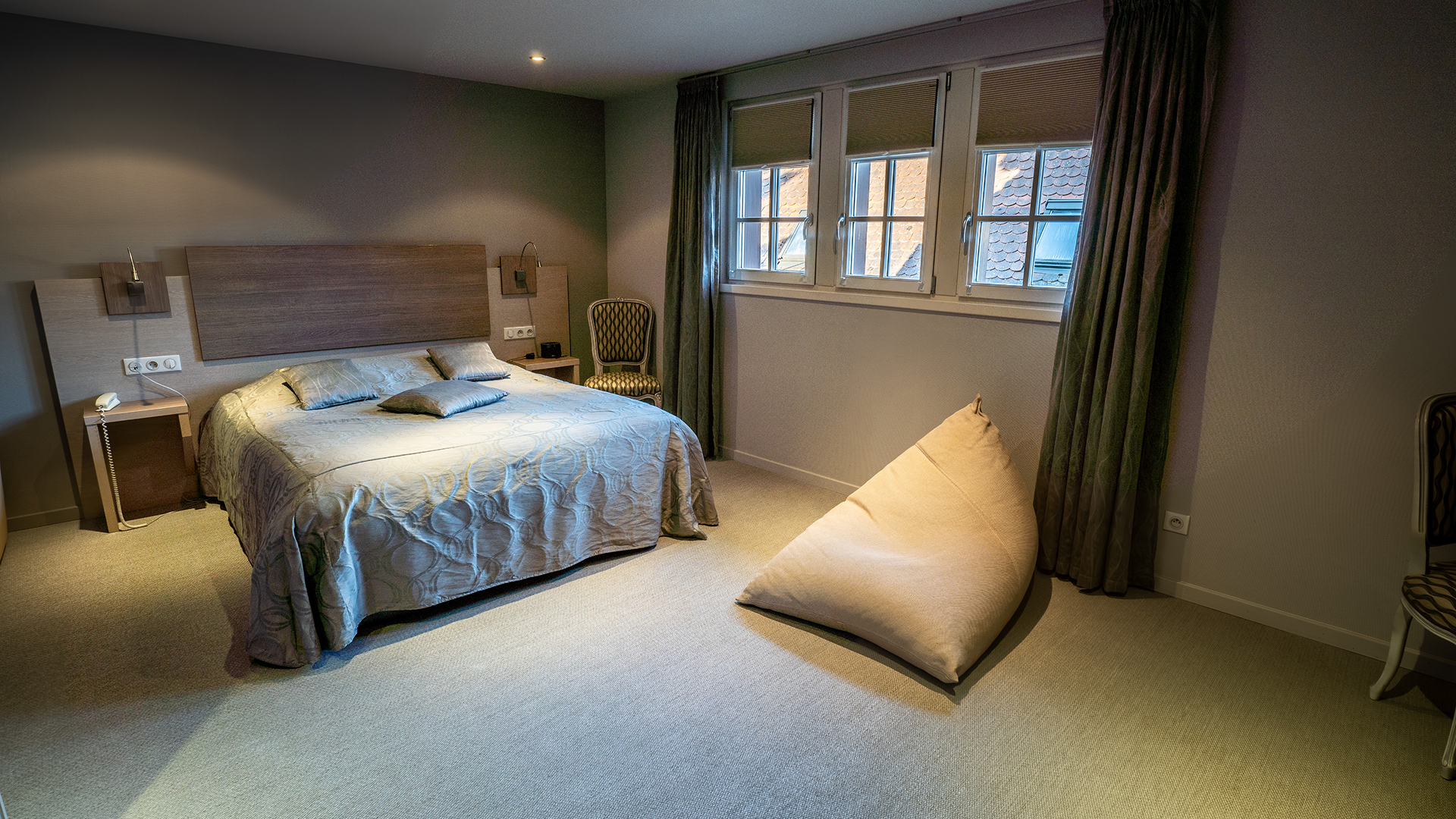Vue générale de la chambre 34 avec lit double, fauteuil et grandes fenêtres